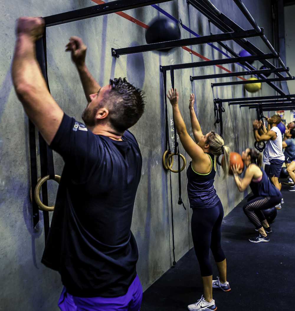 Group conditioning class performing wall balls at 365 Performance